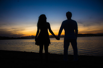 couple giving hands at the sunset 