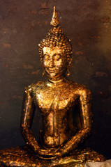 Buddha statue covered with offering of golden leaves (wai phra) at Wat Yai Chai Mongkhon temple in Ayutthaya, Thailand.