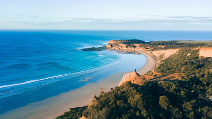 Fototapeta na wymiar Aerial View of Beautiful Beach Coastline with Person on top of Cliffs Along the Great Ocean Road Australia