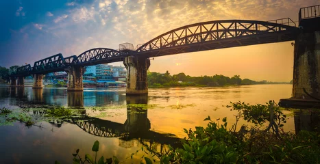 Fotobehang The bridge on the river Kwai at sunrise. Railway in Kanchanaburi, Thailand. Panorama © Olga Khoroshunova