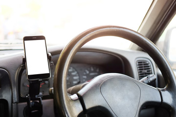 Cropped shot view The driver uses the phone while driving. Modern smart phone with round edges....