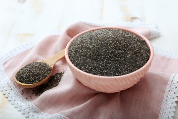 Spoon and bowl with chia seeds on table