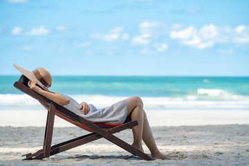 Selective focus of young asian adult traveler in casual wear sleeping on sunbed on sand beach in...