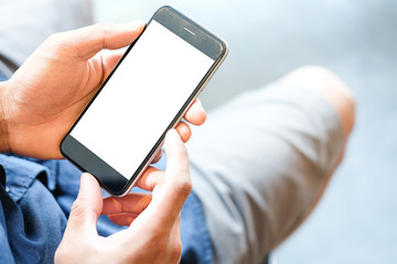 Cropped shot view of man hands holding smart phone with blank copy space screen for your text message or information content, female reading text message on cell telephone during in urban setting.