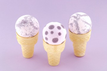 bath bomb set. Purple speckled organic bath bombs with flower extract in waffle cones on a  purple...