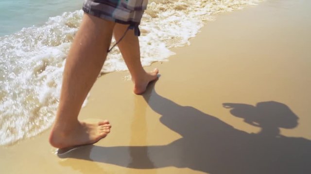 details unrecognizable man walking by the sea clear yellow sand the waves wash the feet