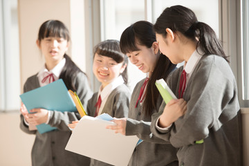 窓際で談笑をする女子学生