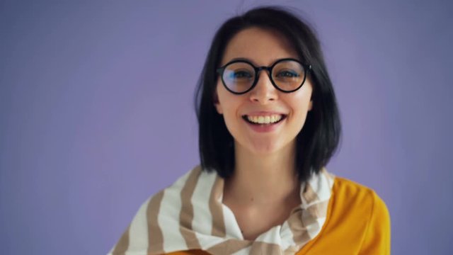 Close-up portrait of joyful woman making funny faces enjoying funny activity standing alone against purple background. Playful girls and silly people concept.