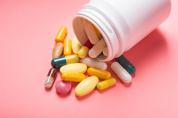 White bottle of medical colored pills and capsule