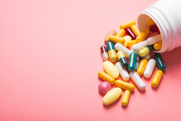 White bottle of medical colored pills and capsule