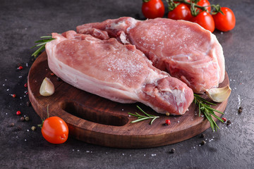 Raw pork steak on a wooden board