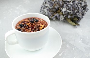 Mixture herbal floral tea with petals, dry berries and fruits. healthy drink. Hot fruit, healthy tea in a white mug