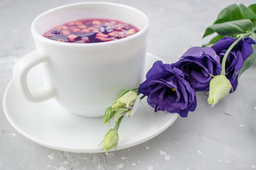 Mixture herbal floral tea with petals, dry berries and fruits. healthy drink. Hot fruit, healthy tea in a white mug