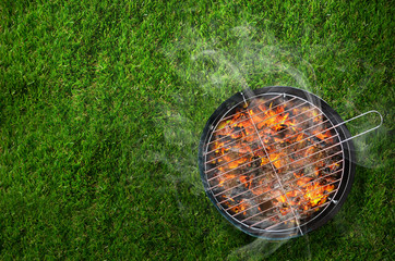 Burning barbecue on grass background - obrazy, fototapety, plakaty