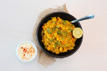 Dal khichadi or Masala Khichdi is a Tasty Indian recipe made of mixed Lentils & rice combined with onions, garlic, tomatoes, Carrots, Peas, cauliflower and beans. Served with Curd or Yogurt & lemon 