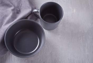Empty black bowl and mug on the gray table.