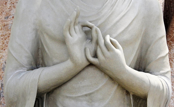 Closeup of hands in meditation pose of Buddha statue