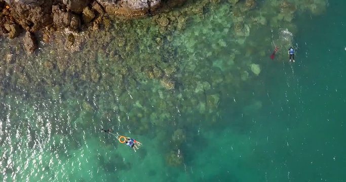 swimmers snorkeling in Adamant sea near Myanmar, sunset time and super clear water