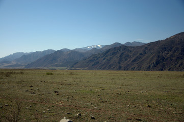 A picturesque fertile valley surrounded by mountains stretching beyond the horizon. Altai, Siberia,...