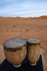 Traditional berber drums, music instrument, during sunrise in the Erg Chebbi sand dunes in the Sahara Desert, Merzouga, Morocco