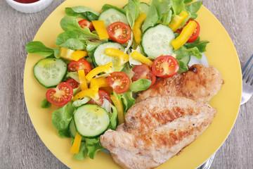 Grilled chicken breast with raw vegetables salad