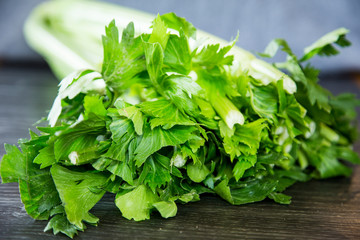 Fresh bunch of celery bought from the local supermarket for a delicious winter stew in the slow cooker. Vibrant green leaves, pale green stalks sitting on a wood grain kitchen bench. Tops are trimmed.