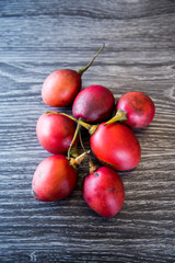 Homegrown, organic tamarillos or tree tomatoes picked from home orchard. Autumn fruit packed with vitamin c to strengthen immune system to prepare for winter. Shown isolated on a dark background.