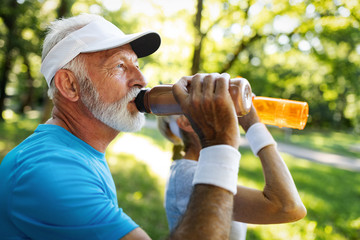 Closeup portrait, thirsty senior man drinking water outside