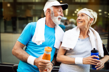 Healthy senior, couple jogging in the city at early morning with sunrise