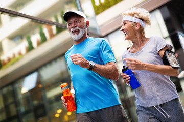 Senior woman and man running doing fitness exercises