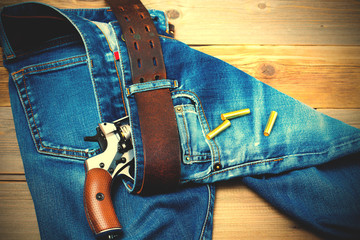 revolver nagant with cartridges in old blue jeans