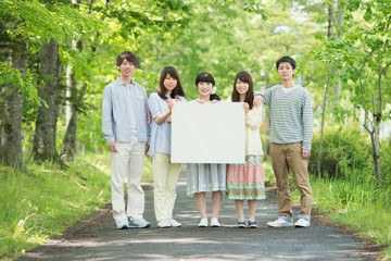 メッセージボードを持ち微笑む大学生