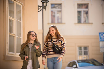 Two happy young women walking on the streets