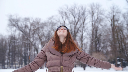 Fototapeta na wymiar Woman enjoy the falling snowflakes