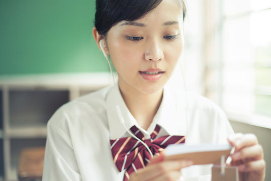教室で暗記カードを確認する女子高校生