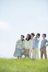 草原で空を見上げる大学生