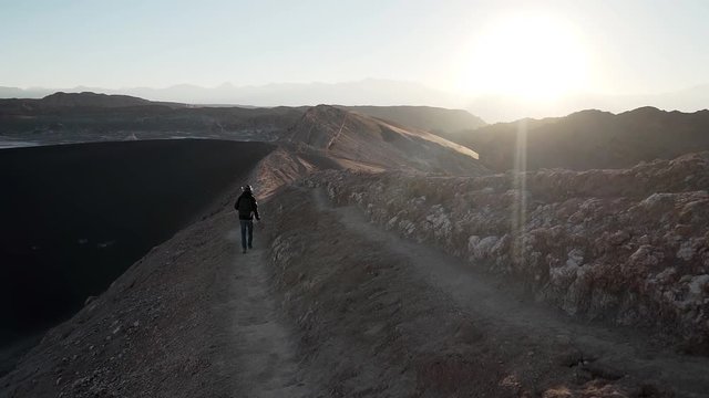 Man walking on a trekking mountain at sunrise in the desert