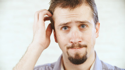 Obraz premium Male person not sure scratching on the head