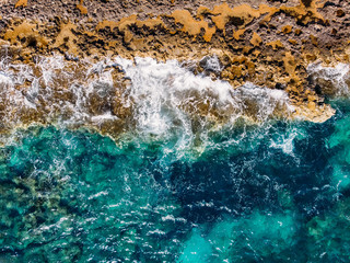 Power of sea to sharpen stone of shore, azure water Caribbean. Top view