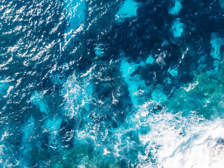 Pure turquoise blue water with fine waves and texture. Top view aerial.
