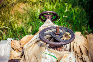 two rusty valves on an outdoor pipe that supplies gas or water