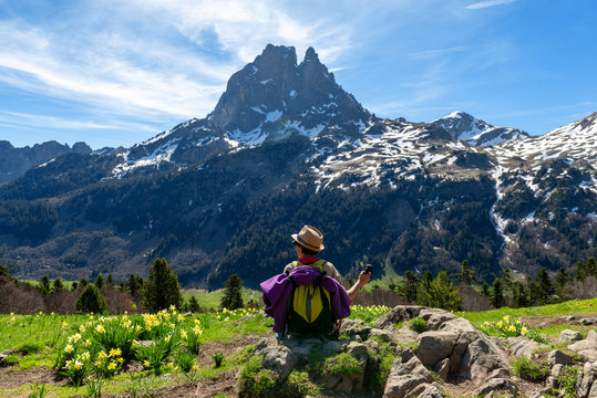 hiker woman resting and looking the Pic du Midi Ossau in the french Pyrenees mountains
