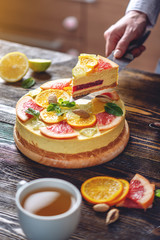 A piece of raw citrus cake with grapefruit, orange, lime and lemon. Cooking healthy summer vegan dessert