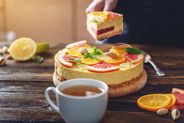 A piece of raw citrus cake with grapefruit, orange, lime and lemon. Cooking healthy summer vegan dessert
