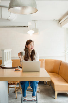 カフェでパソコンを操作する20代女性