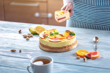 A piece of raw citrus cake with grapefruit, orange, lime and lemon. Healthy fresh summer dessert. Homemade vegan food