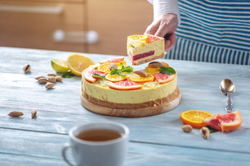A piece of raw citrus cake with grapefruit, orange, lime and lemon. Healthy fresh summer dessert. Homemade vegan food