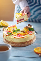 A piece of raw citrus cake with grapefruit, orange, lime and lemon. Healthy fresh summer dessert. Homemade vegan food