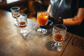 Female bartender holding a glass with coctail