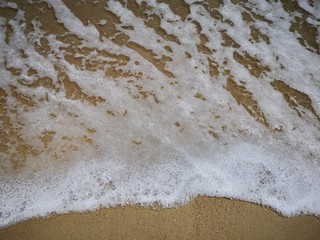 Beautiful splashing swash silky smooth water on the beach during sunny day.